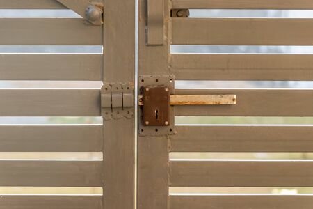 Gray metal driveway entrance gates, closeup view