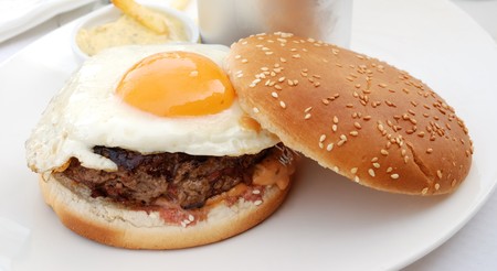 delicious isolated american burger with prepared egg on tableの写真素材