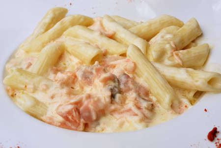 close-up of plate of penne, with fresh salmon and cream sauceの写真素材
