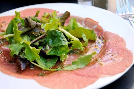 isolated sliced of raw beef in white plate 