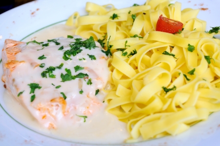close-up of plate of tagliatelle and steamed salmon with cream sauce の写真素材