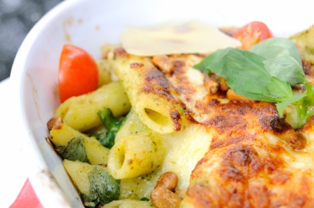 isolated delicious gratin made with penne, chicken and pesto in little casserole  の写真素材