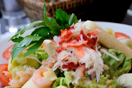 Isolated fresh seafood salad, with crab, shrimp, raw salmon, avocado,  and lettuceの写真素材