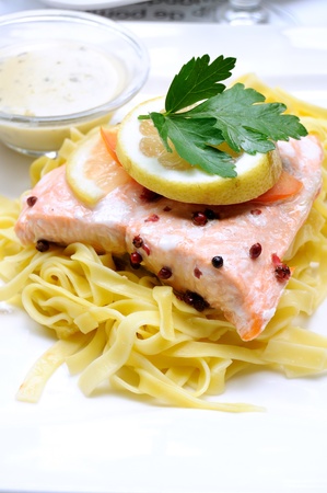 delicious steamed salmon with tagliatelle and lemon isolated in white plate の写真素材