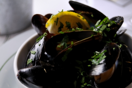 isolated mussels with lemon and garlic in a white bowlの写真素材