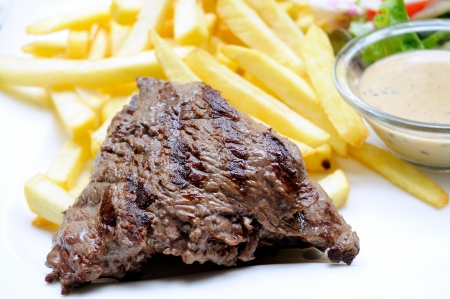 closeup of a grilled steak with french fries on backgorundの写真素材