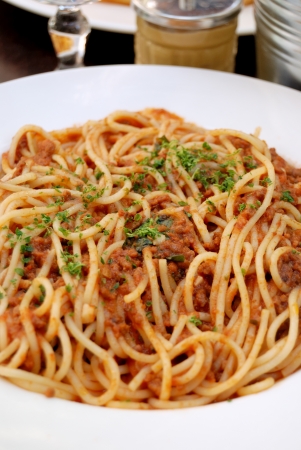 close-up of plate of bolognese pasta with meat, tomato sauce and spaghetti in white plateの写真素材