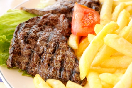 closeup of a grilled steak with french friesの写真素材