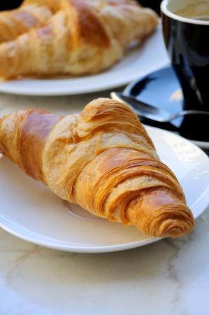 close-up of french breakfast with croissants in white plate, coffee and croissants in backgroundの写真素材