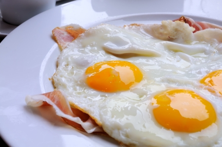 close-up of isolated fried eggs and bacon in white plate の写真素材