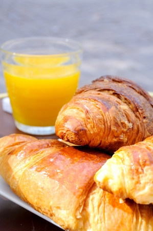 close-up of french breakfast with croissants in white plate and orange juice in backgroundの写真素材
