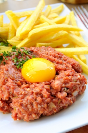 Raw beef with egg and friesの写真素材