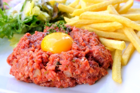 Raw beef with egg and friesの写真素材