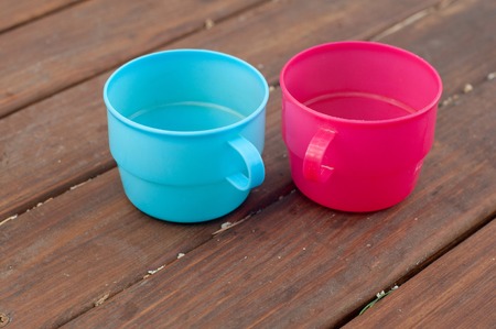 Blue and pink empty cups on wooden tableの写真素材
