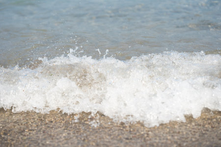 Sea, ocean blue waves with white foam on sandy beach background. Summer day, relax, copy space for...