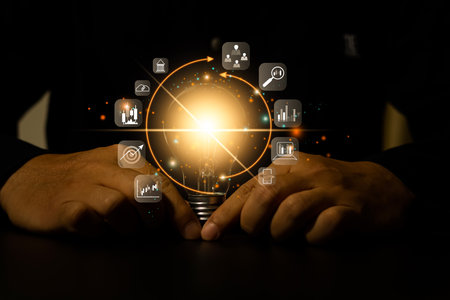 Businessman touching glowing light bulb with learning icon for education knowledge and goals...