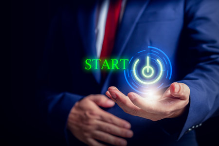 Businessmen in suits hold virtual power buttons with glowing "START", representing startups, technology, and digital innovation.の写真素材