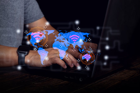 The image shows global internet connectivity via digital technology. Hands are typing laptop with a...