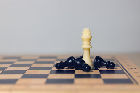 White chess king surrounded by pawns on chessboard, symbolizing leadership, teamwork, strategy, business planning, and decision making.の写真素材