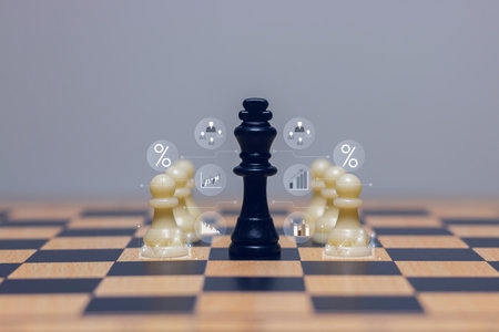 Black king chess piece surrounded by white pawns on wooden chessboard, symbol of leadership, teamwork, power, business strategy and competition.の写真素材