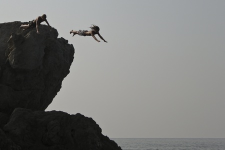 Alupka, Ukraine - August, 18, 2010. Two unidentified young men jumped into the sea from a cliff. The action took place in Alupka on the beach のeditorial素材