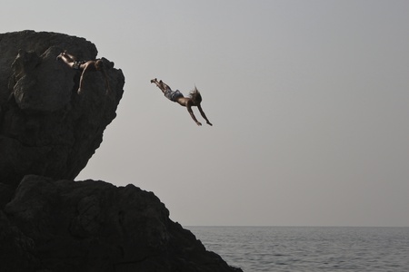 Alupka, Ukraine - August, 18, 2010. Two unidentified young men jumped into the sea from a cliff. The action took place in Alupka on the beach のeditorial素材