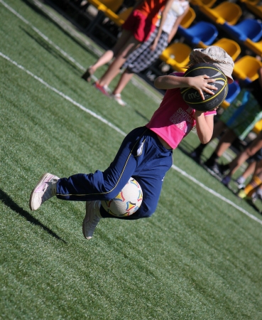 SVIATOHIRSK, UKRAINE - JULY 30, 2012: Unidentified child with two balls in a fun relay race in the childrenのeditorial素材