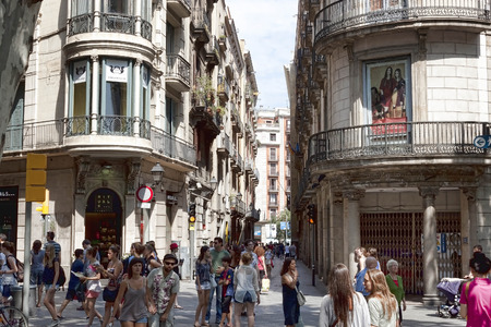BARCELONA, SPAIN - JULY 13, 2013: Narrow street that crosses Ramblas - a pedestrian street in the center of Barcelona. There is always a lot of touristsのeditorial素材