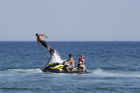 CAMYUVA, KEMER, TURKEY - JULY 16, 2015: Unidentified Turkish man demonstrates flyboard acrobatics on the beach of Camyuva. Extreme water sports are increasingly popular on the beaches of Turkeyのeditorial素材
