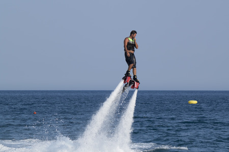 CAMYUVA, KEMER, TURKEY - JULY 12, 2015: Unidentified Turkish man hovered above the water. Extreme water sports are increasingly popular on the beaches of Turkeyのeditorial素材