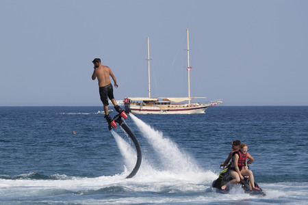 CAMYUVA, KEMER, TURKEY - JULY 16, 2015: Unidentified Turkish man hovered above the water. Extreme...
