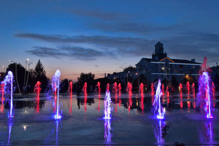 KRAMATORSK, UKRAINE - JUNE 15. 2019: The fountain with colour lights on the main square of Kramatorsk in the summer evening - entertainment not only for children, but also adultsのeditorial素材