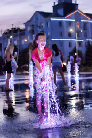 KRAMATORSK, UKRAINE - JUNE 18. 2019: The fountain with colour lights on the main square of Kramatorsk in the summer evening - entertainment not only for children, but also adultsのeditorial素材