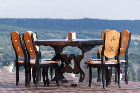A table and several chairs on a pedestal, which rises on the mountain. Against a breathtaking sky...