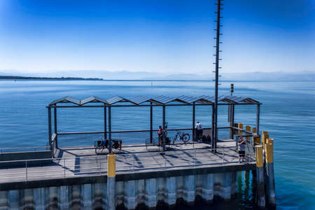FRIEDRICHSHAFEN, GERMANY - JUNE 14, 2022: Fishermen on the pier in Friedrichshafen. Photo from the upper deck of the ferryのeditorial素材