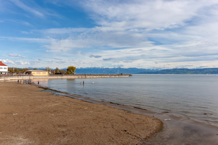 A wide, tranquil panorama of Lake Constance (Bodensee) stretches out from the sandy and pebbled...