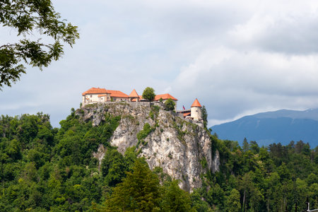 Bled Castle, a medieval fortress, stands majestically atop a steep cliff overlooking Lake Bled, Sloveniaの写真素材
