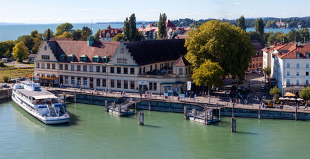 LINDAU, BAVARIA, GERMANY - AUGUST 31, 2025: Panoramic view of the waterfront promenade in Lindau, Germany, featuring the historic old train station building and a passenger ferry docked on Lake Constance (Bodensee)のeditorial素材