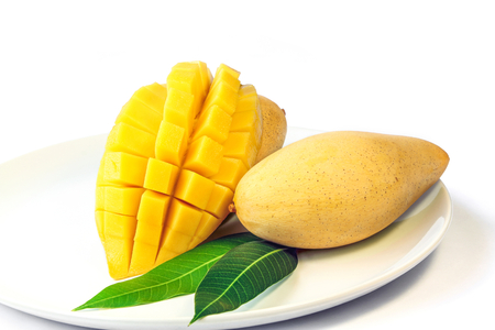 Mango fruit with leaves on a dish isolated on white background.の写真素材