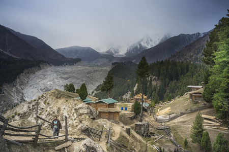 Fairy Meadows, Pakistan - October 5, 2017: A Pakistani man was walking near the bonfire at Fairy Meadows, Pakistan. The background is Nanga Parbat mountain.のeditorial素材