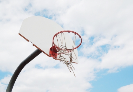 Outdoor basketball hoop with blue sky and cloudsの写真素材