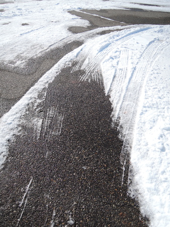 Tracks of car tires in thin layer of first snowの写真素材