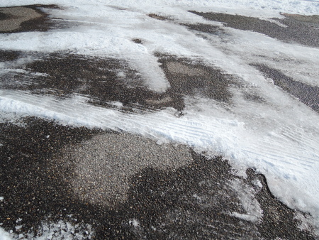 Tracks of car tires in thin layer of first snowの写真素材