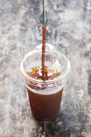 A cup of Ice coffee on wooden table in coffee shop.の写真素材