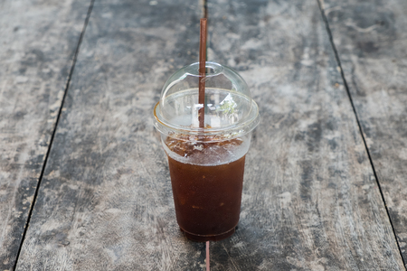 A cup of Ice coffee on wooden table in coffee shop.の写真素材