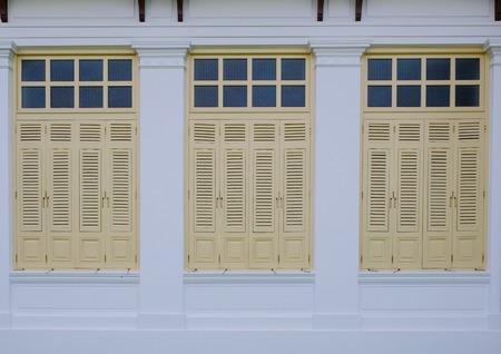 The wooden yellow windows on white wall in Thailand.の写真素材