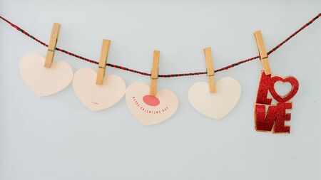 Red word LOVE  on rope with clothespins, on a white  backgroundの写真素材
