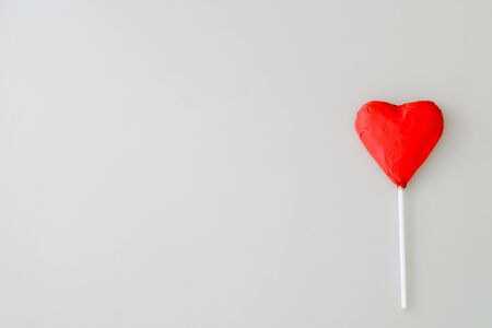 Heart shaped chocolate candy with red wrappings on a white backgroundの写真素材