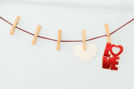 Pink hearts and word LOVE on rope with clothespins, on a white  backgroundの写真素材