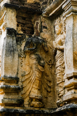 Beautiful ancient stucco carving life size deities on wall of historic Wat Chet Yot or Wat Jed Yod buddhist temple, famous landmark of Chiang Mai, Thailandの写真素材